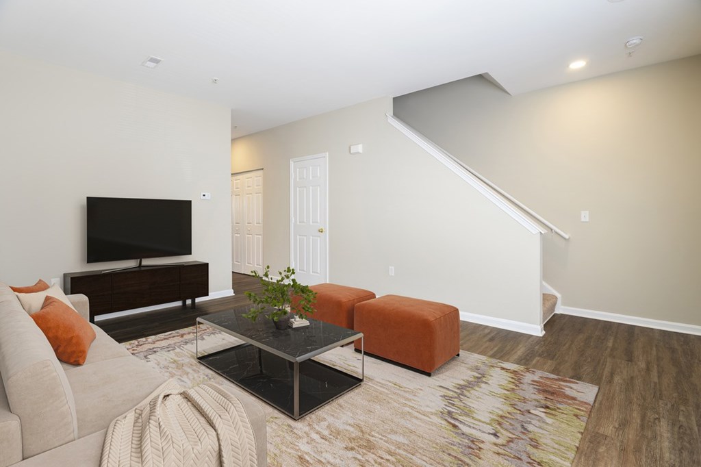 A living room with a couch, coffee table, and a television.